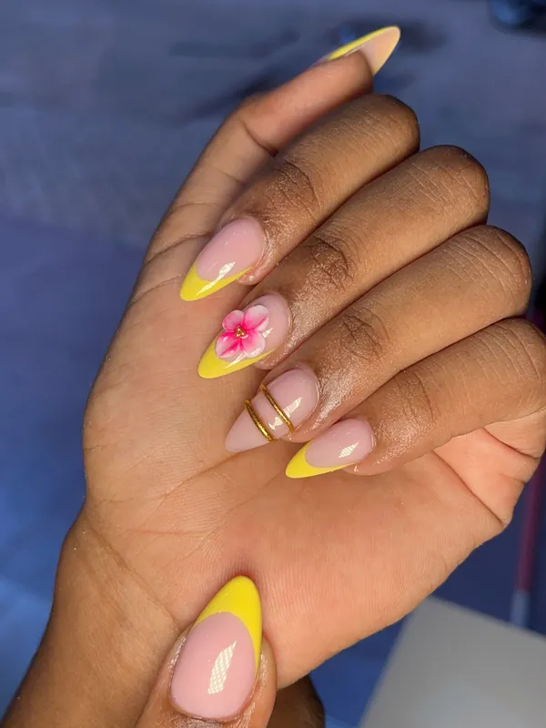 Yellow French tip nails with flower accent